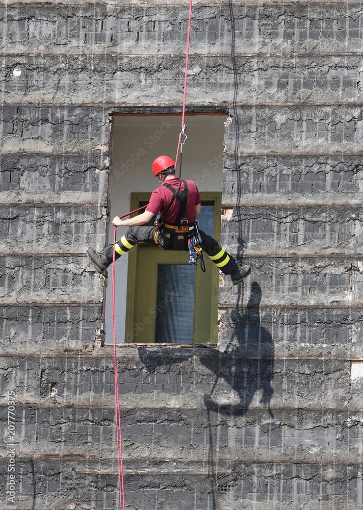 climber firefighter rappelling the wall Stock Photo