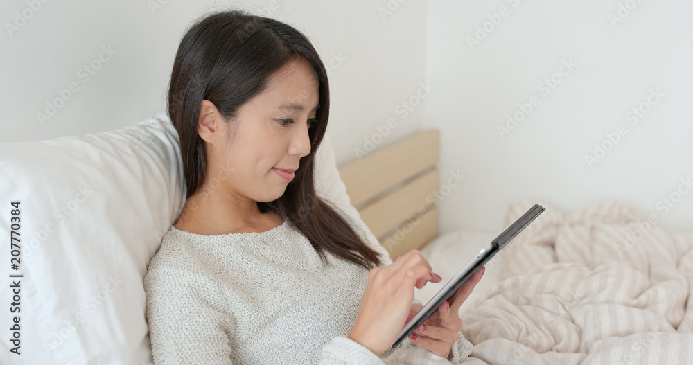 Woman watching on tablet computer on bed Woman watching on tablet computer on bed