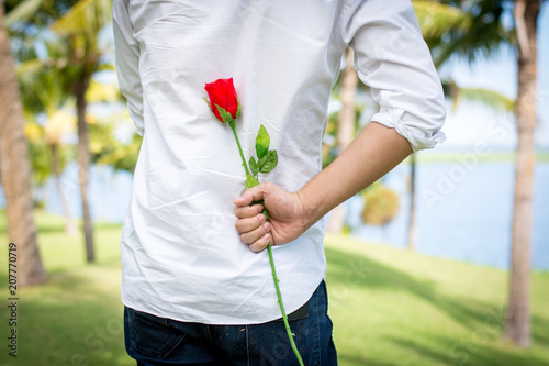 Foto Man holding roses behind.
