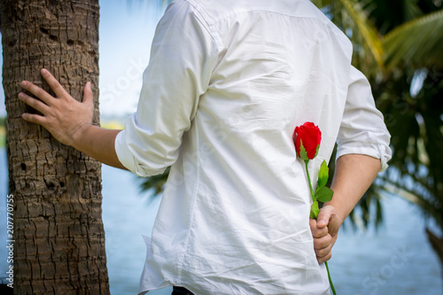 Foto Man holding roses behind.