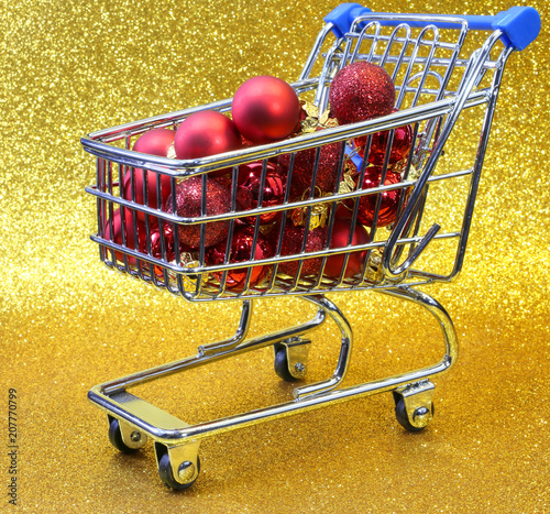 shopping cart with red decorative Christmas balls and golden bac