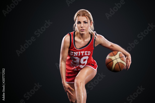 Portrait of a beautiful and sexy girl with a basketball in studio. Sport concept isolated on black background. © Mike Orlov