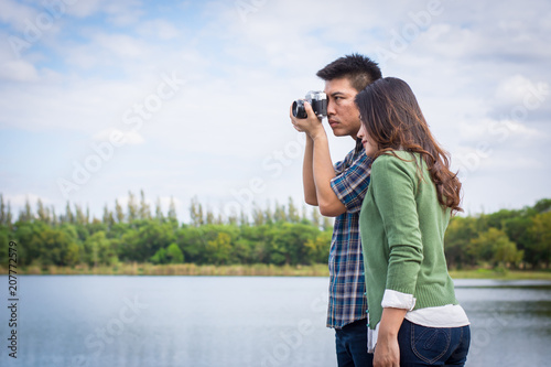 Obraz na plátně Young men and young women Couple together standing on bench waterfront port in the park