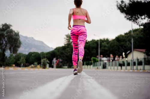 Wallpaper Mural Back view of slim woman running along the highway in the morning Torontodigital.ca