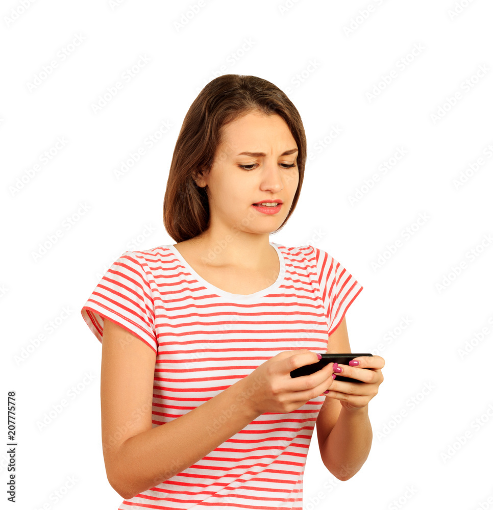 unhappy young woman writes a message on the phone. emotional girl isolated on white background unhappy young woman writes a message on the phone. emotional girl isolated on white background