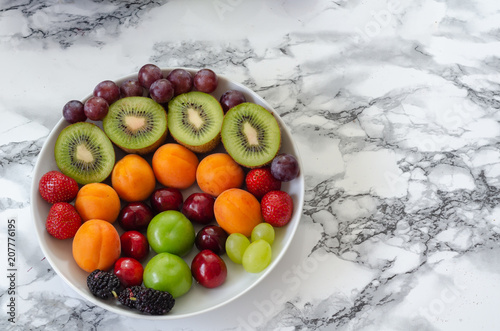 Fresh colorful fruits in white plate. Healthy nutrition  diet concept.
