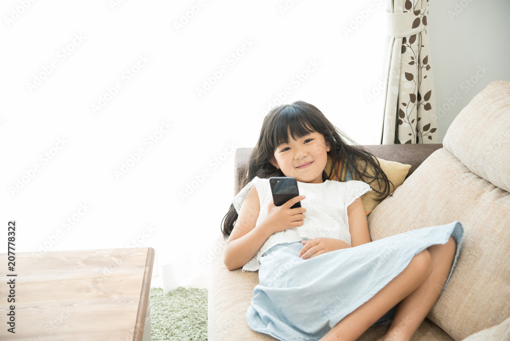 スマートフォンを持つ小学生の女の子 スマートフォンを持つ小学生の女の子