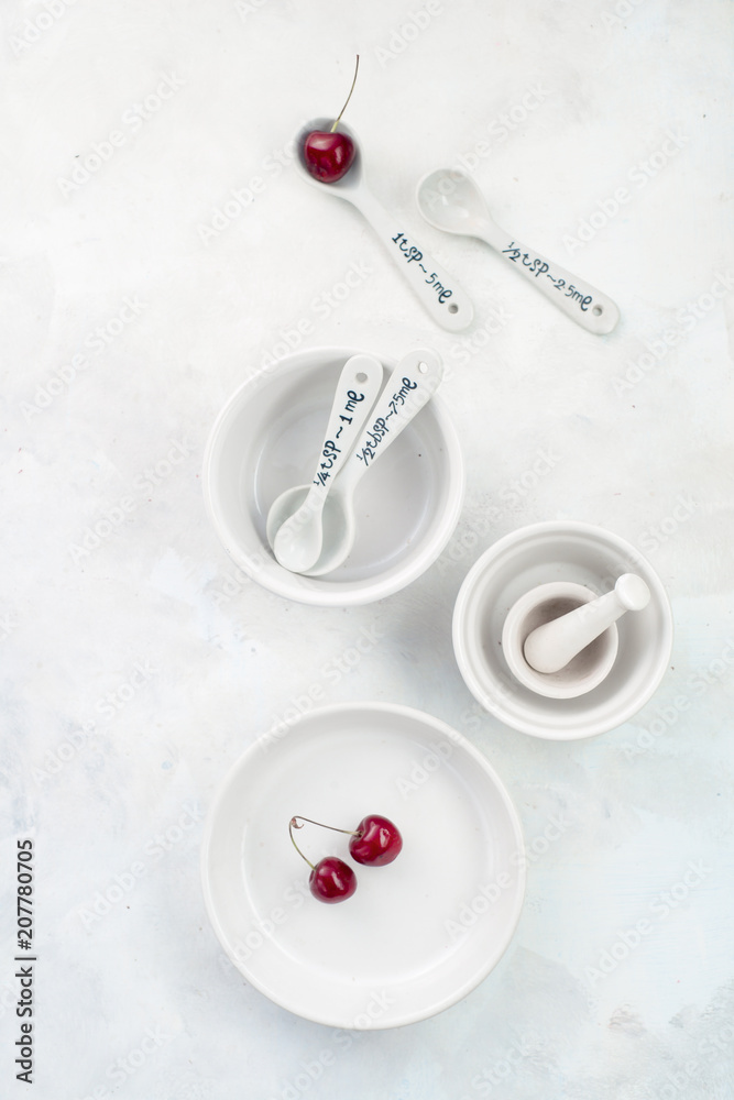 Minimalist empty porcelain dishes on a white stone background with copy space. Cherry pie baking concept. Minimalist empty porcelain dishes on a white stone background with copy space. Cherry pie baking concept.