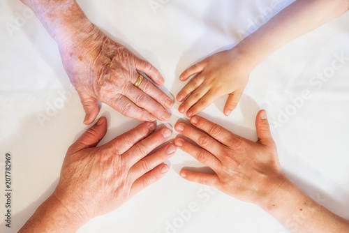 Hände mehrerer Generationen berühren sich die Finger.