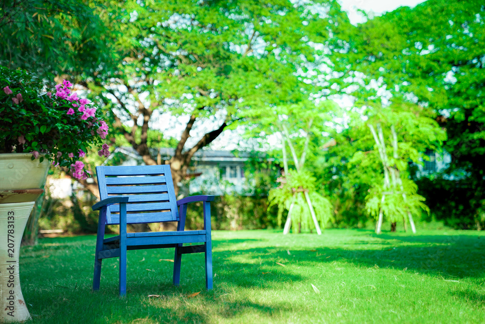 One Wooden blue chair alone in the garden. Feel lonely, but relaxing and retirement One Wooden blue chair alone in the garden. Feel lonely, but relaxing and retirement