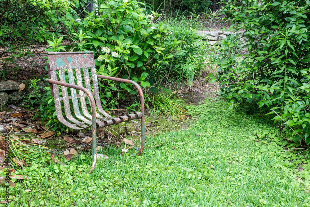 Old metal chair, green ground cover, copy space, death grief absence concept, horizontal aspect Old metal chair, green ground cover, copy space, death grief absence concept, horizontal aspect