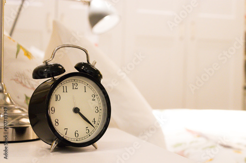 Black alarm clock on the bedside table