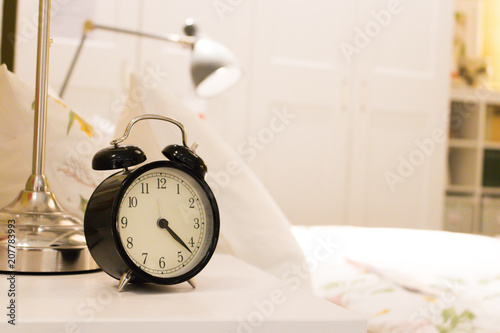 Black alarm clock on the bedside table