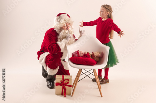 Christmas portrait of cute little newborn baby girl, dressed in christmas clothes, studio shot, winter time