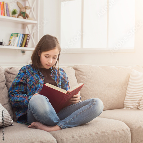 Cozy home. Young thoughtful girl with book © Prostock-studio