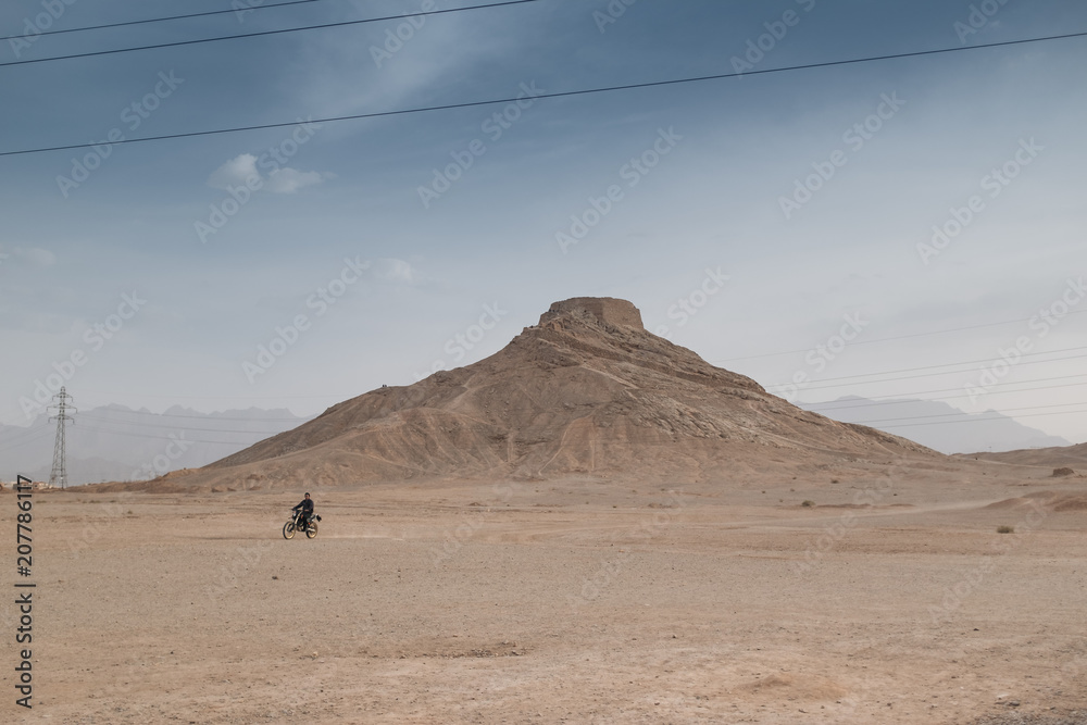 Man on motorbike in front of Tower of silence