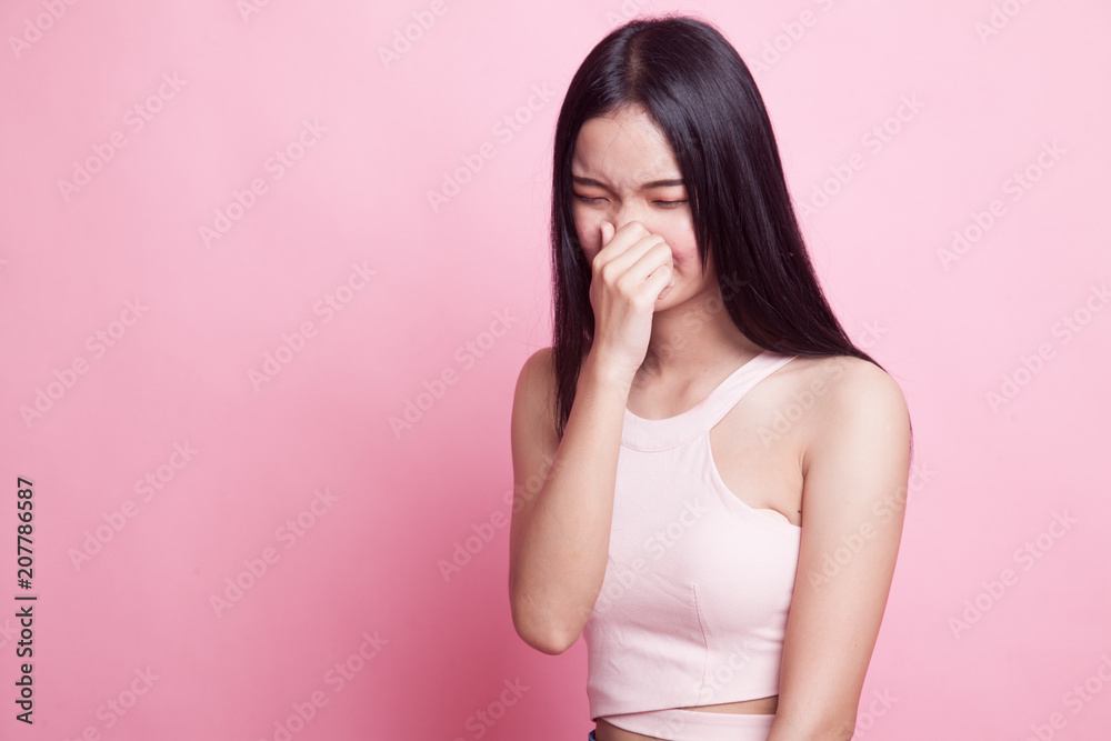 Young Asian woman holding her nose because of a bad smell. Young Asian woman holding her nose because of a bad smell.