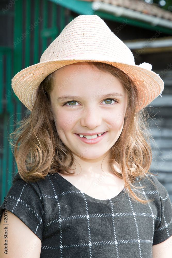 Cute little child hat girl at black dress in a beautiful park