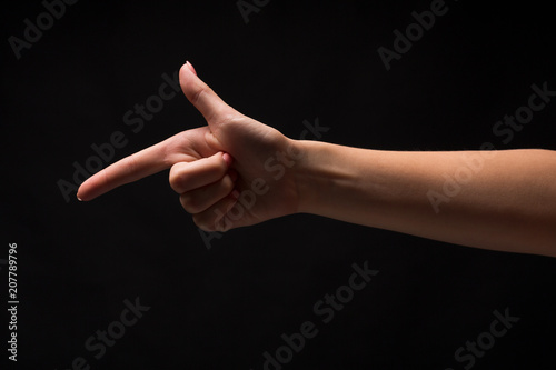 Hand gestures - woman pointing, isolated at black