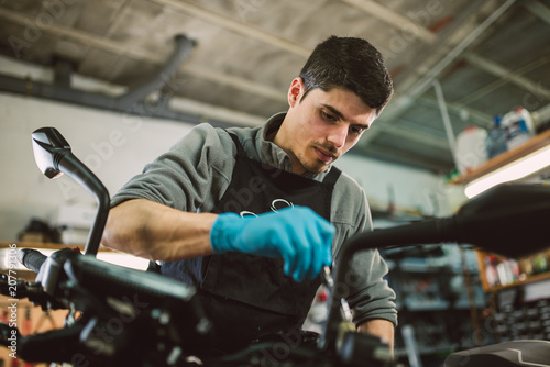 Mechanic polishing and cleaning a motorcycle © ramonespelt
