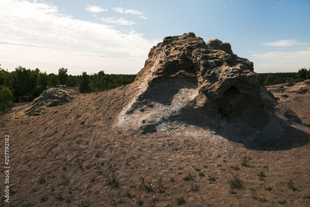 Fototapeta premium Big rock surrounded by sand