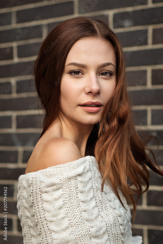 portrait of a girl half-turned on a brick wall background portrait of a girl half-turned on a brick wall background