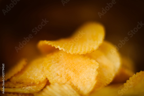 junk fast food and unhealthy eating. crispy chips. crunchy potato crisps closeup with selective focus on dark background