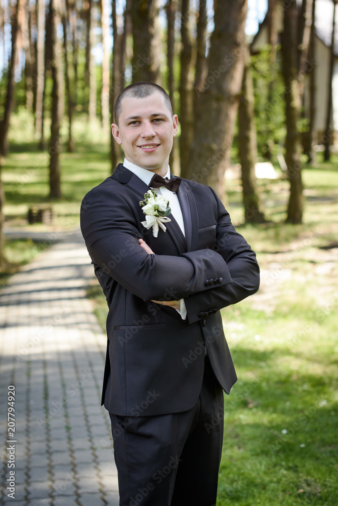 young wedding groom posing outdoors on wedding day young wedding groom posing outdoors on wedding day