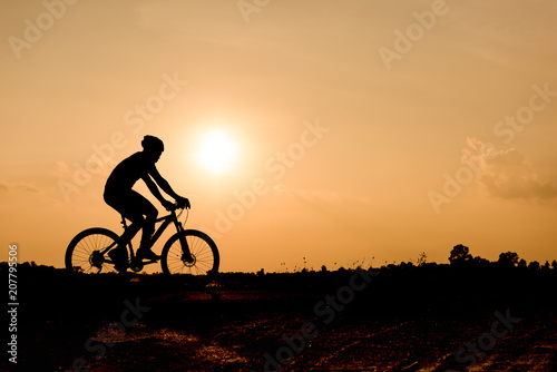 Silhouette of cycling on sunset background.