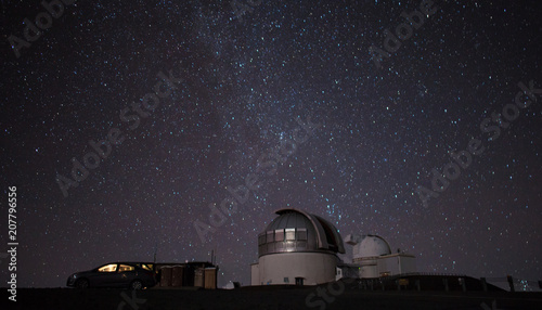 Starry night sky and the milky way over a telescope in Hawaii