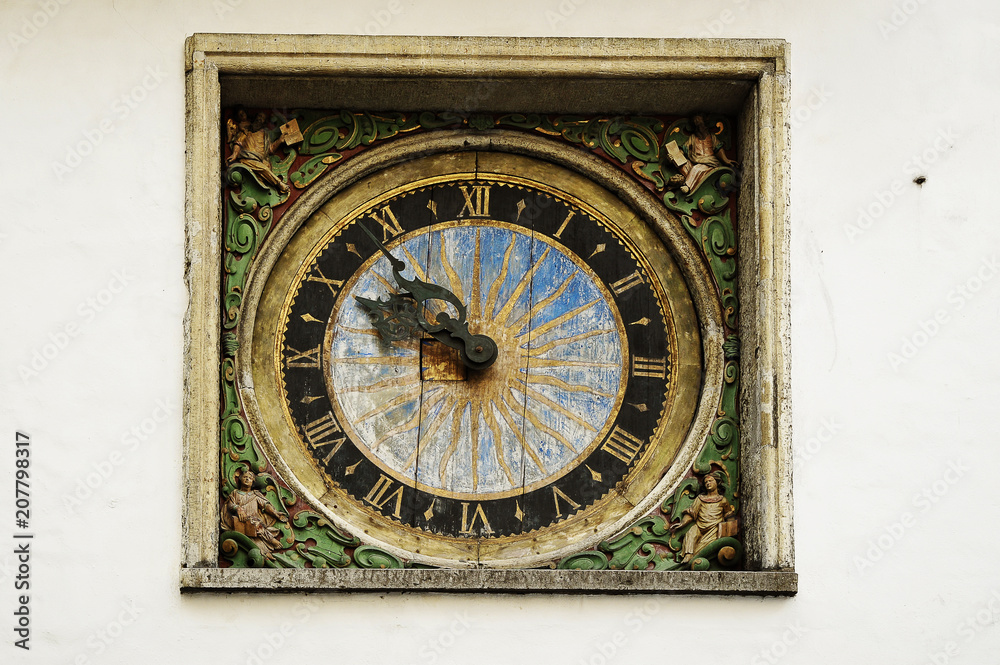 old clock on the wall of the church in the old town