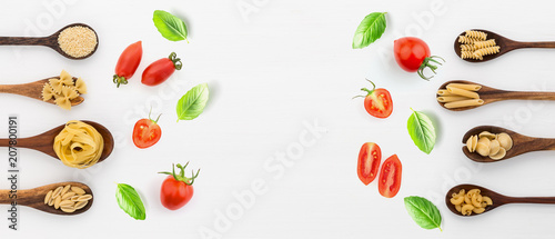 Fototapeta Naklejka Na Ścianę i Meble -  Panoramic view different kind of pasta on wooden spoon and ingredients on white background from top view. Italian food concept. Banner