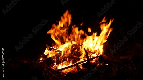 Video footage of a burning and sparking campfire at night with burning woods in 4K resolution.