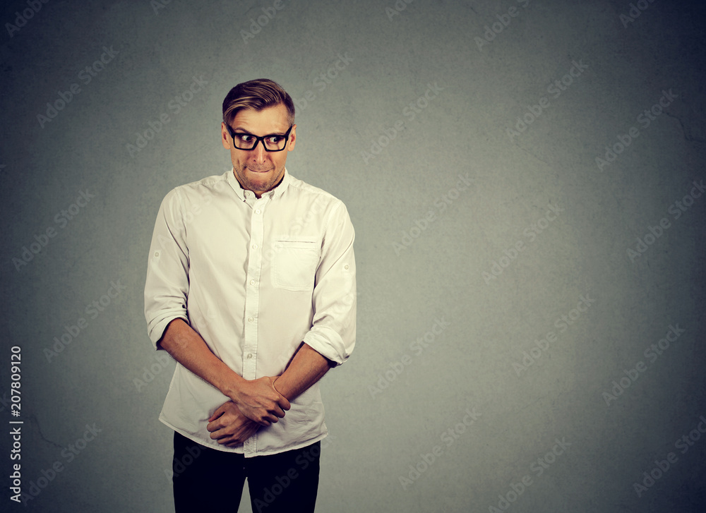 Embarrassed nerd guy on gray