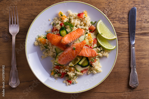Salmon with tomato couscous, zucchini and lime. View from above, top studio shot