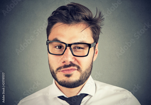 Young man looking with mistrust annoyed with situation