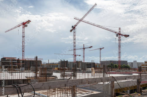 Several Cranes on a Large Construction Site with Dramatic Sky