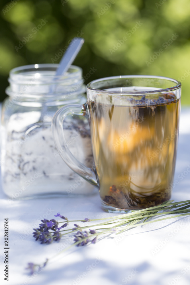 Herbal lavender tea in glass cup with lavender flowers Herbal lavender tea in glass cup with lavender flowers