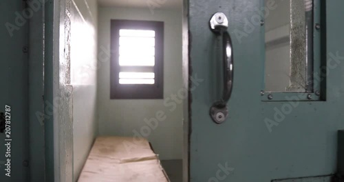Door of solitary confinement cell opening in old prison.