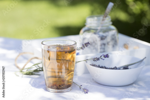 Herbal lavender tea in glass cup with lavender flowers