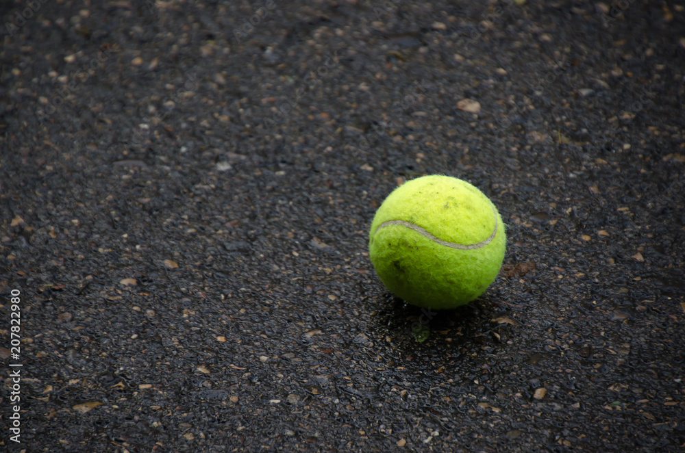 Tennis ball on the asphalt ground