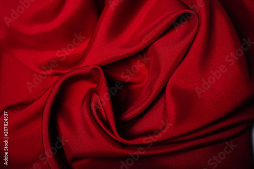 Red fabric in the folds. drapery. shine on silk. Sewing