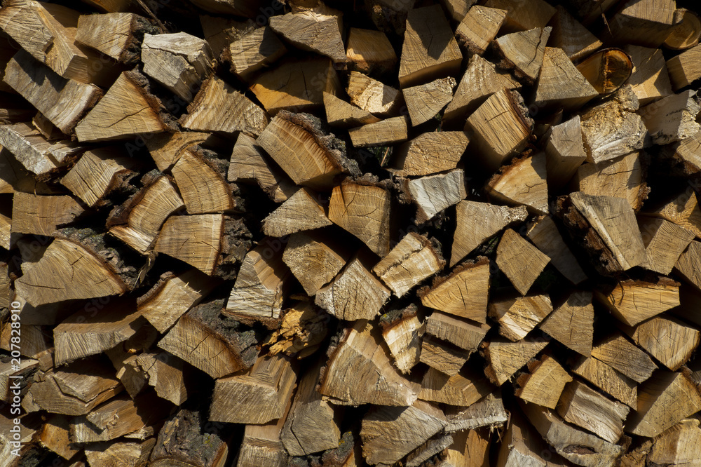 Pieces of different sizes are forming this wood pile of chopped pieces of pine, oak and other trees, ready to be burned into the fireplace during winter time. Pieces of different sizes are forming this wood pile of chopped pieces of pine, oak and other trees, ready to be burned into the fireplace during winter time.