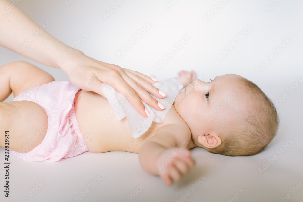 Hygiene - young momy wiping the baby skin with wet wipes. Cleaning wipe, pure, clean Hygiene - young momy wiping the baby skin with wet wipes. Cleaning wipe, pure, clean