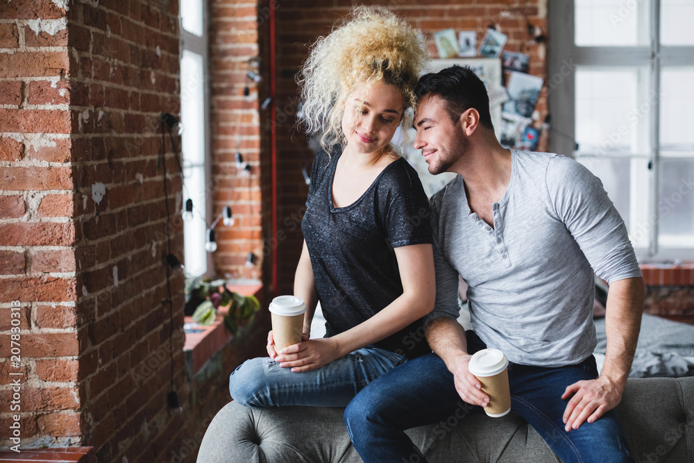 Beautiful young couple smiling and sitting on sofa. Beautiful young couple smiling and sitting on sofa.