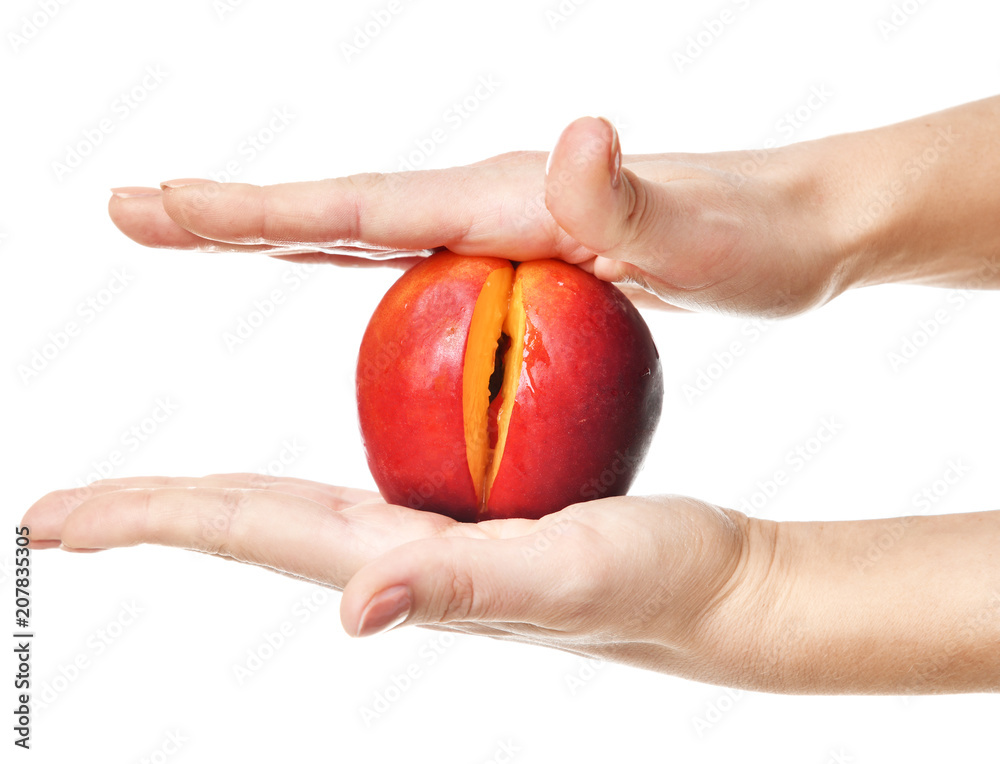 Body care gynecology and woman's health. Close up photo of woman hands with slotted slot peach fruit represent intimate part of female isolated on white Body care gynecology and woman's health. Close up photo of woman hands with slotted slot peach fruit represent intimate part of female isolated on white