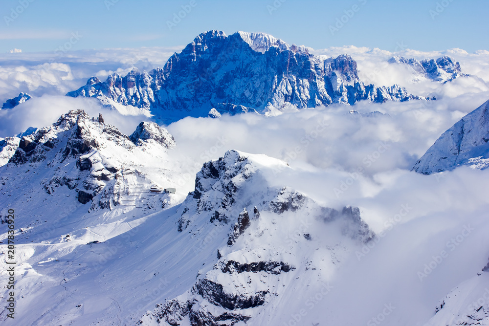 Stunning sunny winter view to peaks in moutains and clouds, Dolomites Alps Italy Stunning sunny winter view to peaks in moutains and clouds, Dolomites Alps Italy