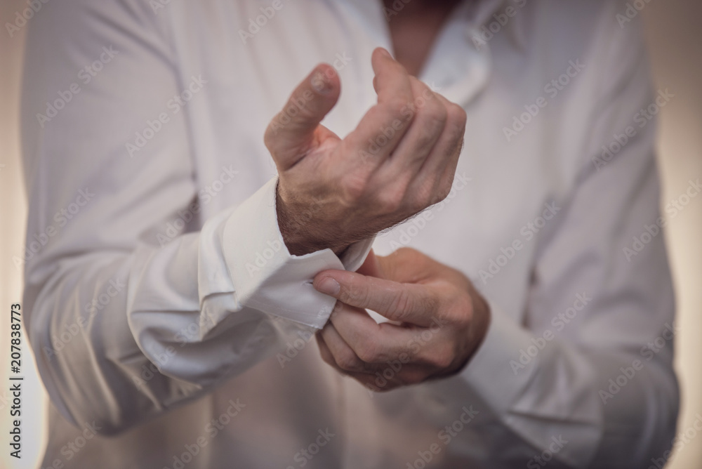 hombre abrochandose las mangas de la camisa Stock Photo | Adobe Stock