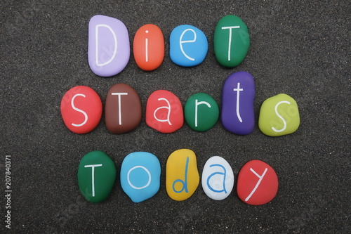 Diet starts today, slogan with colored stones over black volcanic sand