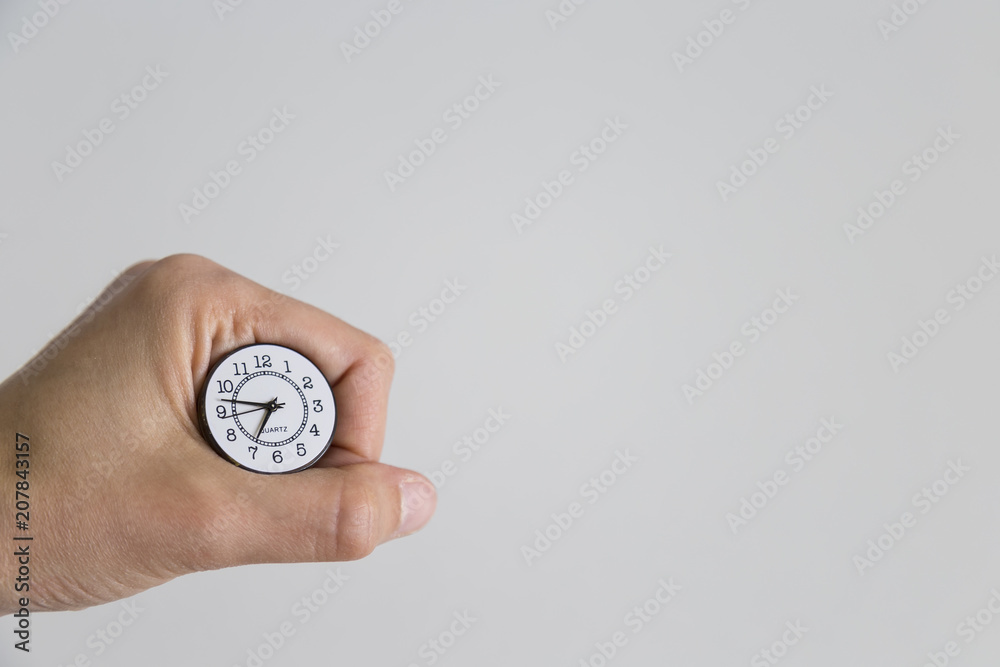 clock with the hand on the white background. time to investment, lesson, reading book and exam. clock with the hand on the white background. time to investment, lesson, reading book and exam.